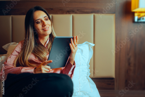 Woman Resting in Bed Checking her Pc Tablet. Relaxed businesswoman working from home feeling cozy 