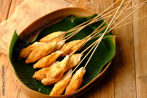 Sempol Sempolan is is a deep fried food made from chicken or fish or shrimp mixed with tapioca flour and spices. served on woven bamboo and banana leaf containers, on a wooden table. Indonesian food. photo