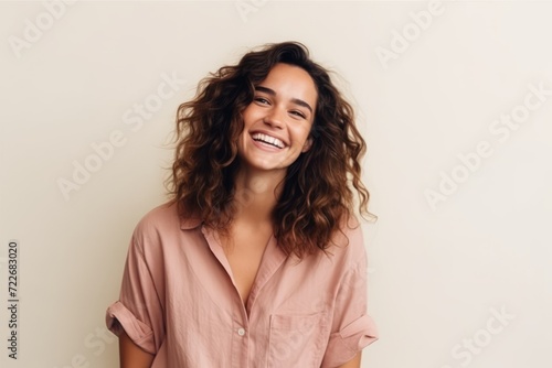 Portrait of a beautiful young woman with long curly hair smiling at the camera