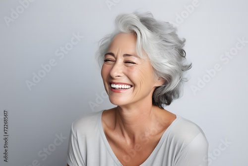 middle-aged woman in her 40s, with white gray hair, smiling beautifully as a skin care product model photo