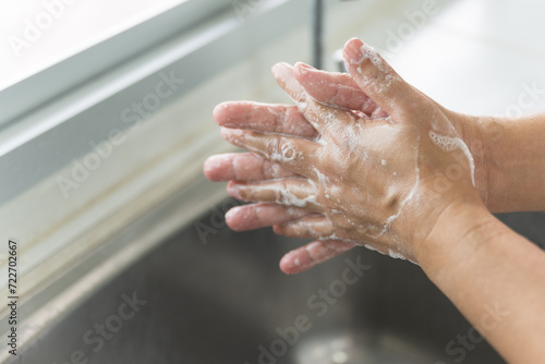 Close up woman hand washing under running water in the kitchen.Hygiene and cleaning hands.Image hand washing step concept.