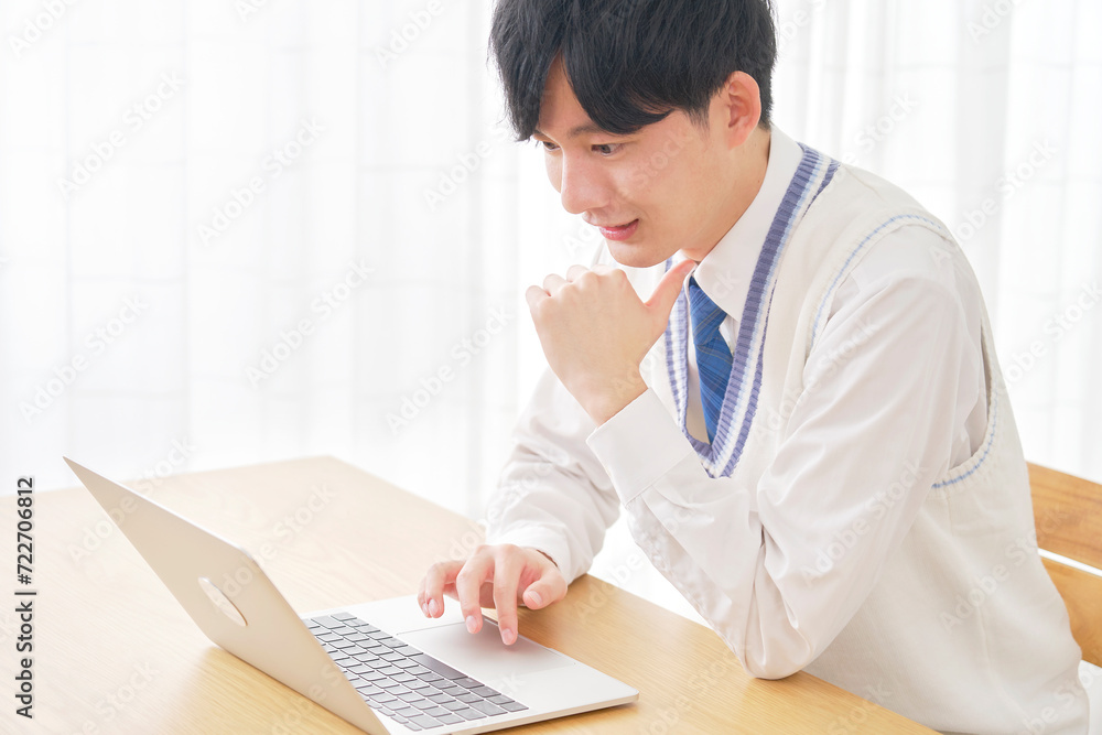 リビングでノートパソコンを使う男子高校生