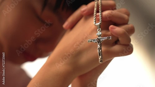 Sense of devotion and spiritual fulfill with christian catholic follower immerse in faith. Slow motion christian holding holy cross while praying to worship the god. Burgeoning photo