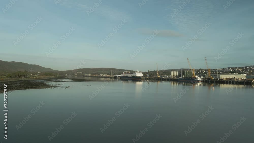 Calm waters reflecting Omeath town and port, clear sky, hills in the distance, morning light, aerial view Calm waters reflecting Omeath town and port, clear sky, hills in the distance, morning light, aerial view