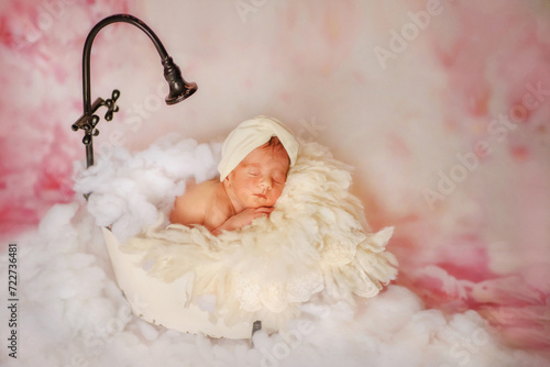 Newborn baby sleeps sweetly. Newborn girl with dark hair and a bow on her head. Baby girl in a white shower cap. The newborn smiles. Baby in a bubble bath. Dream. Portrait of a newborn. Mom's love.