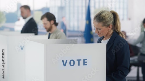 Portrait of a Beautiful Adult Woman Filling Out a Ballot in a Voting Booth on the Day of National Elections in the European Union. Diverse Men and Women Voting for Elected Officials in an EU Country photo