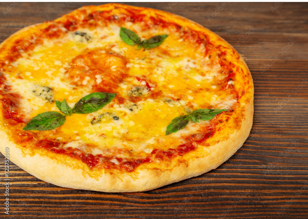 Cheese pizza with basil on a wooden background, close-up Cheese pizza with basil on a wooden background, close-up