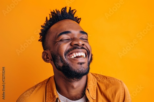 Close up of man enjoying a good laugh, orange studio environment