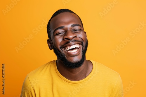Close up portrait of man mid-laugh  orange studio background
