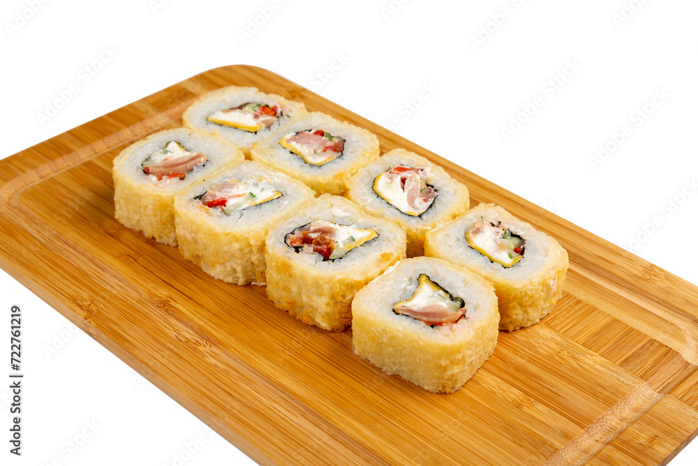 Japanese sushi roll fried with processed cheese, ham and tomato on a wooden board, isolated.