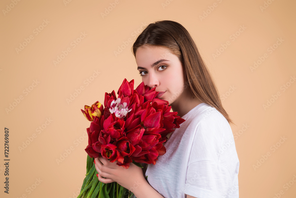 Beauty girl with tulip. Beautiful sensual woman hold bouquet of tulips, studio portrait on beige background.