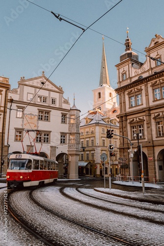 Snowy Prague, retro tram driving through a small square
