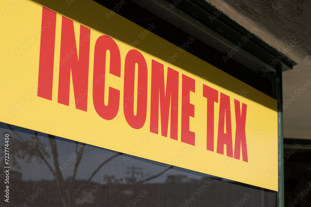 Closeup of the Income Tax sign on the window at the office of a tax preparation service provider. Closeup of the Income Tax sign on the window at the office of a tax preparation service provider.