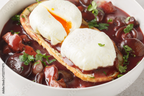Quadro em tela Oeufs en meurette Poached eggs in a red wine sauce with pearl onions, mushrooms and bacon closeup on the plate on the table