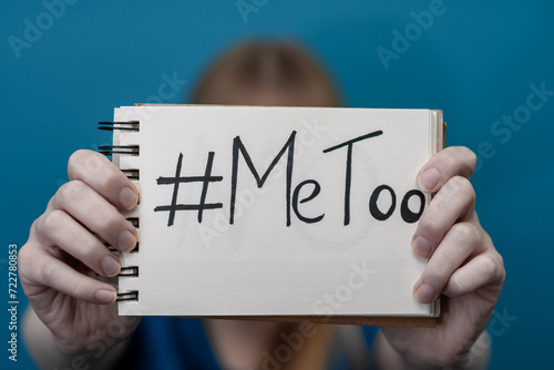 Kobieta trzyma kartkę z napisanym hasztagiem i słowami Me Too, problem molestowania kobiet photo