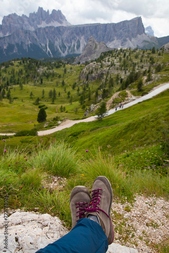 Trekking boots of a hiker while sitting on top of a mountain in Dolomites, Italy © erika8213