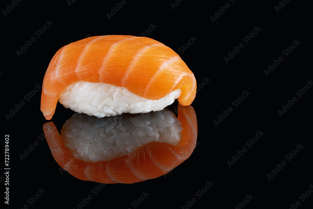 Composition of fresh salmon sashimi sushi isolated on a black background with reflect.A healthy delicacy.Copy space. Place for your text.Billboard. Composition of fresh salmon sashimi sushi isolated on a black background with reflect.A healthy delicacy.Copy space. Place for your text.Billboard.
