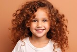 Portrait of a cute little girl with curly hair over brown background