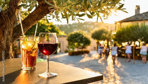 verre de vin et cocktail à la terrasse d'un bar restaurant à l'ombre d'un olivier