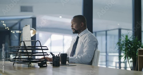 Business, black man and computer at desk in office arrival, work on email or corporate project at night. Table, professional and consultant on technology for deadline, information or online planning photo