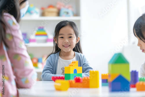 Asian Child Explores Colorful Blocks with Psychologist in Bright Setting