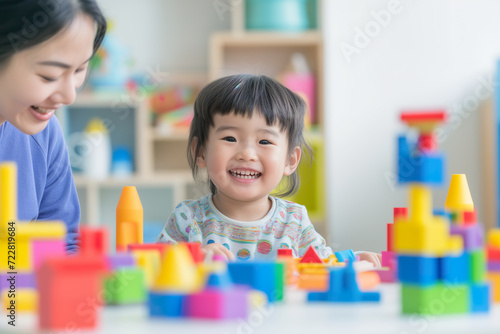 Asian Child Explores Colorful Blocks with Psychologist in Bright Setting