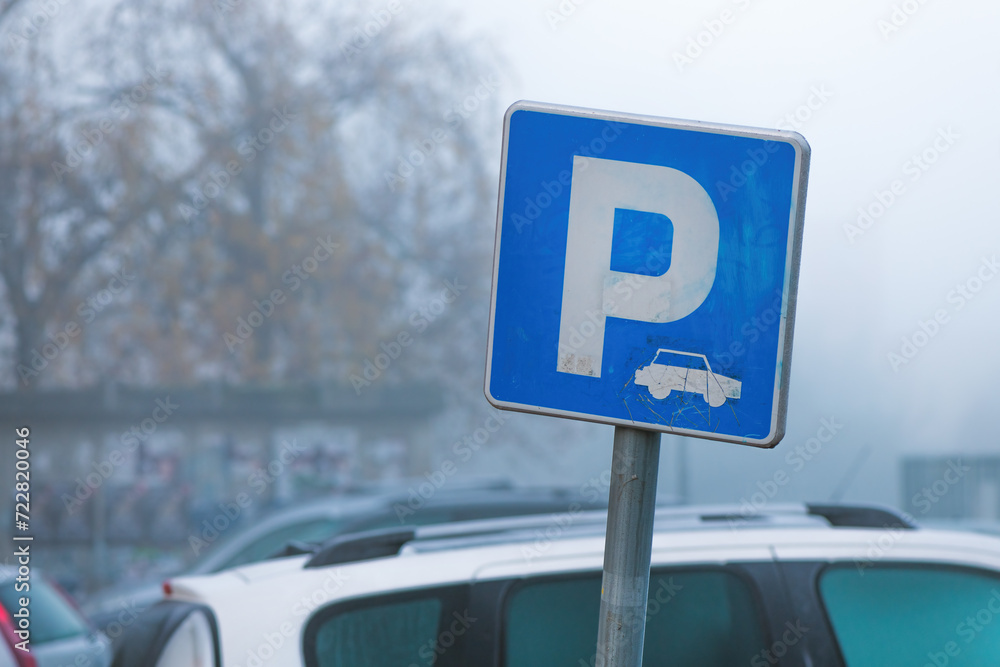 Worn parking sign in foggy winter morning