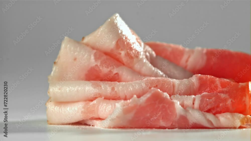 Bacon falling on white background. Filmed on a high-speed camera at 1000 fps. High quality FullHD footage Bacon falling on white background. Filmed on a high-speed camera at 1000 fps. High quality FullHD footage