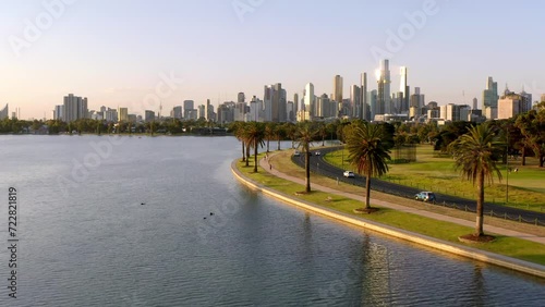 Aerial: Australia Melbourne City Center in Background Evening Golden Hour Flight over Beautiful Albert Park Lake