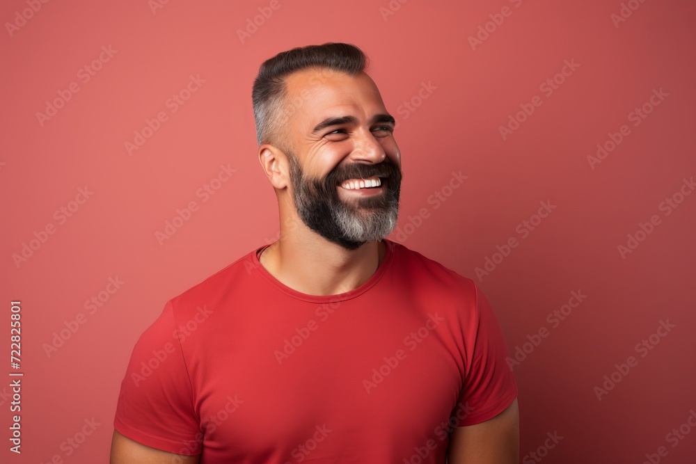 Portrait of a smiling bearded man in red t-shirt on a red background Portrait of a smiling bearded man in red t-shirt on a red background