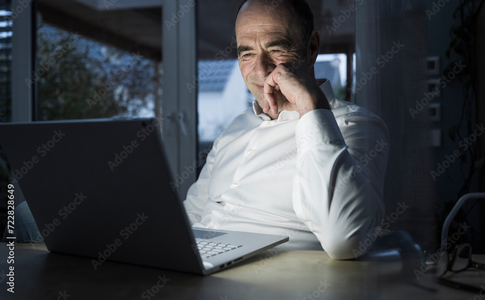 Smiling freelancer having video call through laptop at home office Smiling freelancer having video call through laptop at home office