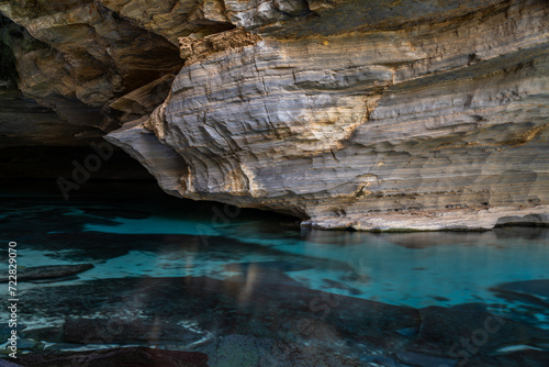 Serene Waters Beneath Ancient Stratified Rock Formations