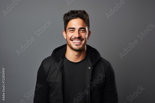 Portrait of a smiling young man in a black leather jacket. © Loli