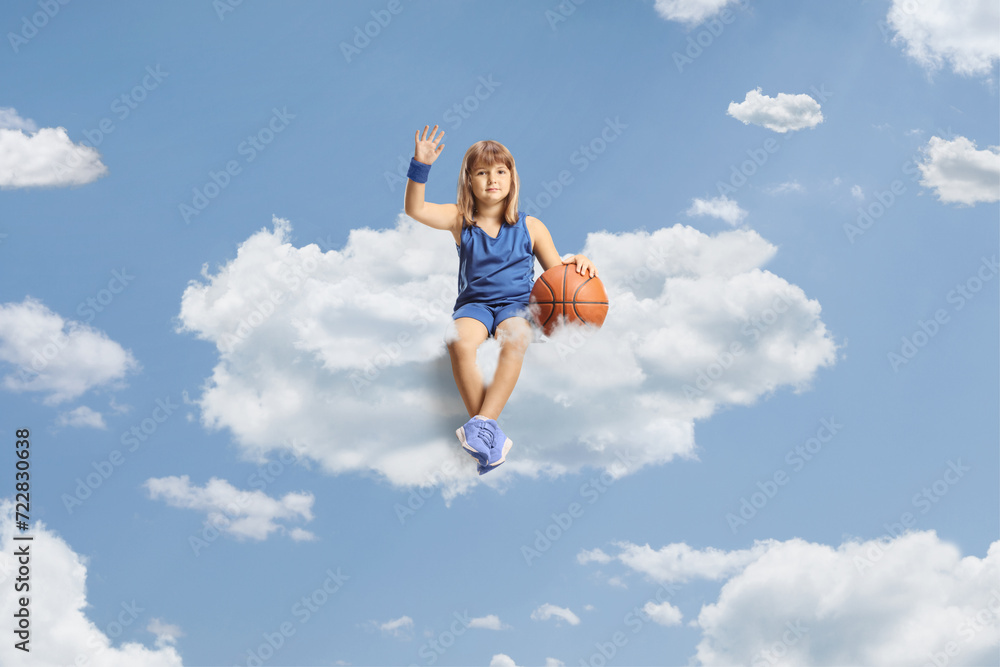 Little girl with a basketball sitting on a cloud