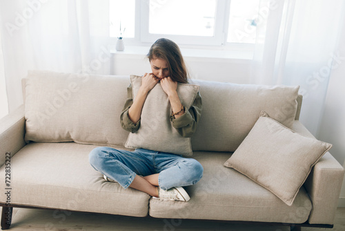 Distressed Woman Resting on Couch, Feeling Sad and Worried, Expressing Mental Health Pain at Home