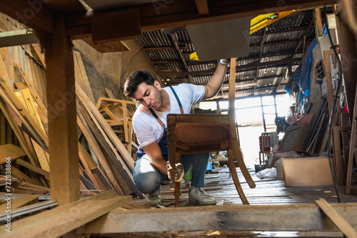 Carpenter man doing diy chair in vintage carpentry wood working shop photo