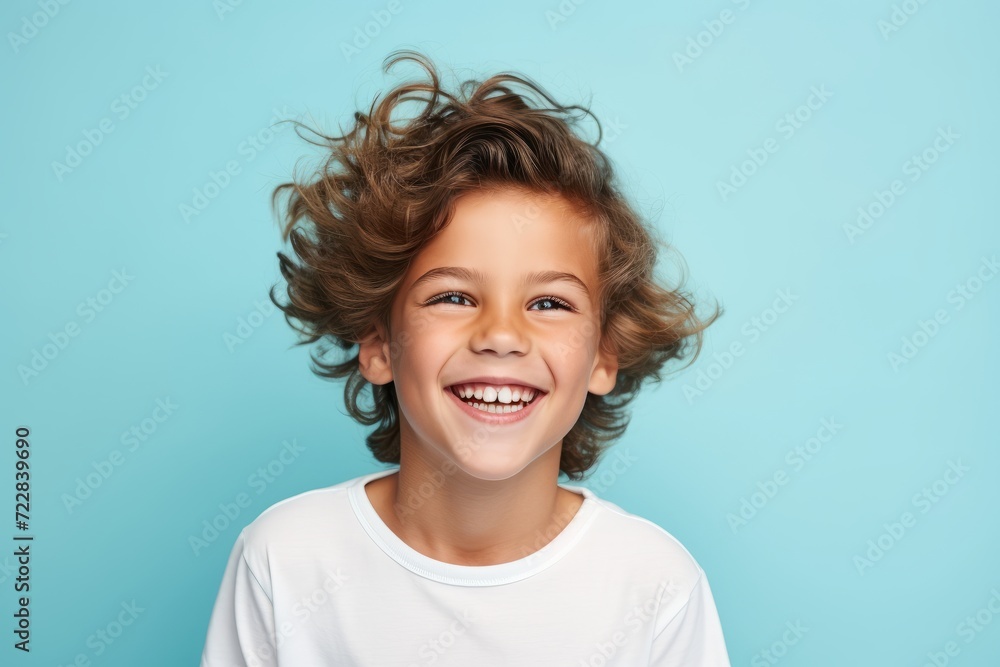Portrait of a smiling little boy with curly hair on a blue background Portrait of a smiling little boy with curly hair on a blue background