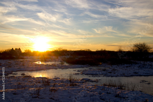 Sunset on snowy meadow on a cold winter day