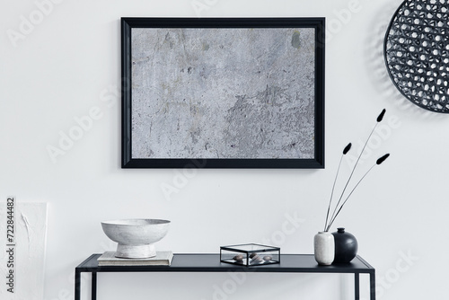 Minimalistic stylish composition of creative room interior design with mock up poster frame, metal shelf and personal accesories. Black and white concept. Template. photo