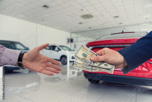 Businessman giving or paying money to dealer at modern car showroom