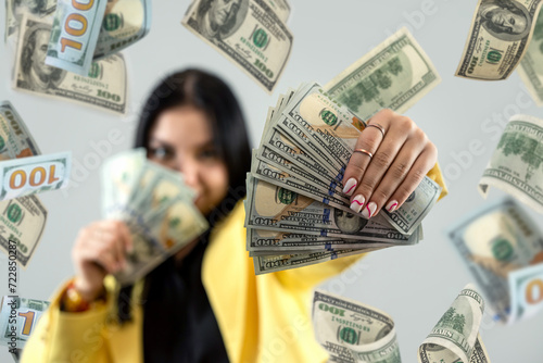 Φωτογραφία Pretty caucasian woman celebrating winning big money, flying dollar bills from the air