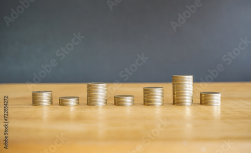 stack of golden money coin on wood desk and black background. Business and financial concept. 