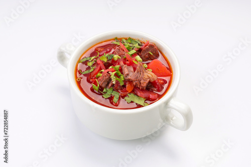 Business lunch. Traditional borscht with beef and sour cream in a white bowl on a white background