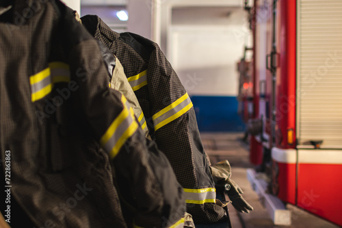 Firefighter's uniforms in a fire station against the background of fire trucks