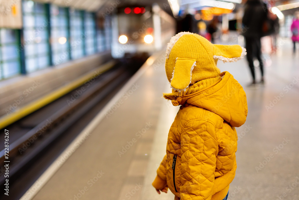 Cute preschool child, boy, standing on a platform in metro, waiting for the subway Cute preschool child, boy, standing on a platform in metro, waiting for the subway