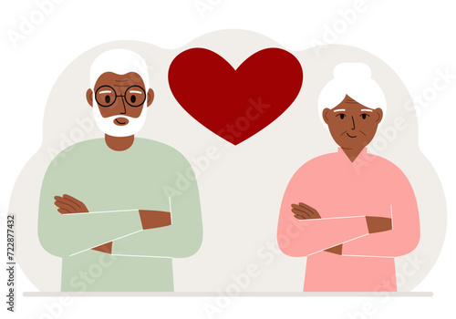 Happy old man and old woman next to a big red heart. Love.