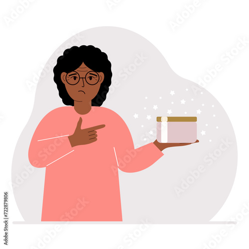 A woman holds a jar of cream in his palm.