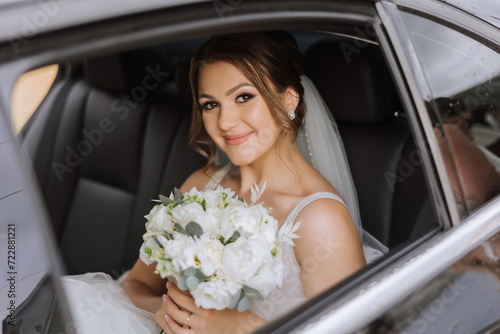 The bride looks out of the car window. Close-up portrait of a pretty shy bride in a car window. Bride smile emotions
