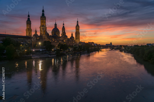 Pilar basilica of the city of Zaragoza reflected on the Ebro river at sunset with a dramatic sky. Aragon, Spain. © JoseLuis