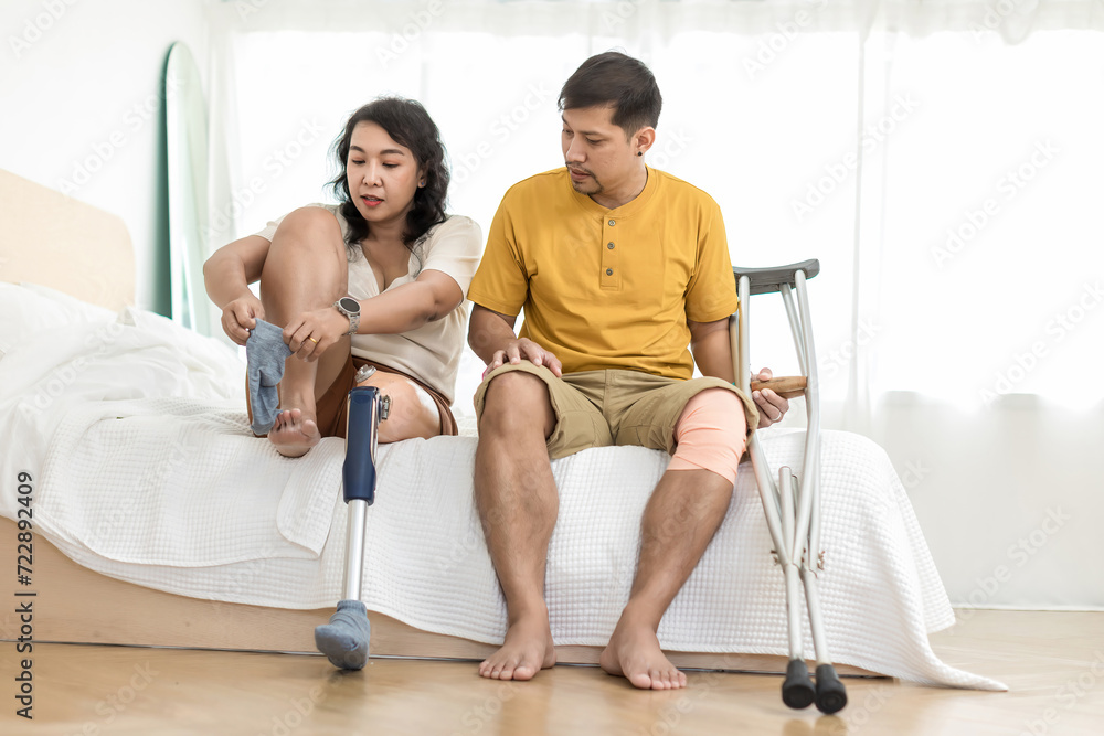 Woman with prosthetic leg sitting in bed in bedroom at home. Relaxed, happy woman at bedroom room sitting on the bed,applying leg prosthetic. Woman with prosthetic leg sitting in bed in bedroom at home. Relaxed, happy woman at bedroom room sitting on the bed,applying leg prosthetic.